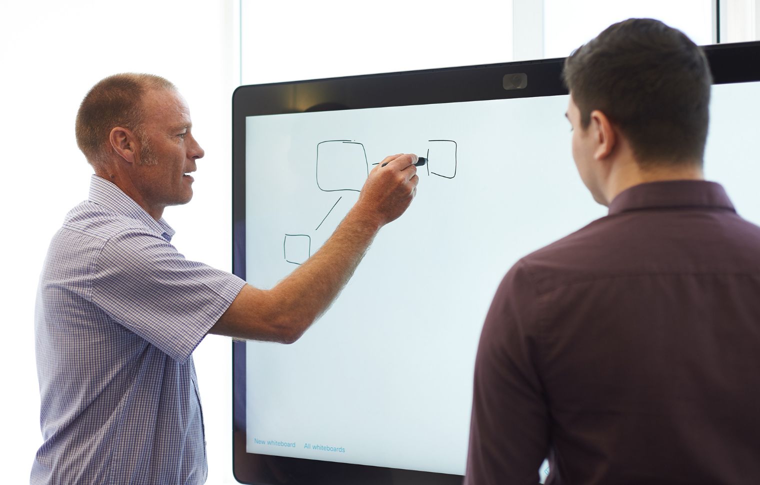 Staff standing using a white board